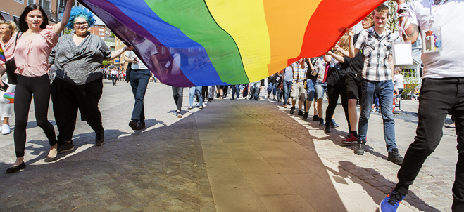 Invånare paraderar med prideflaggan