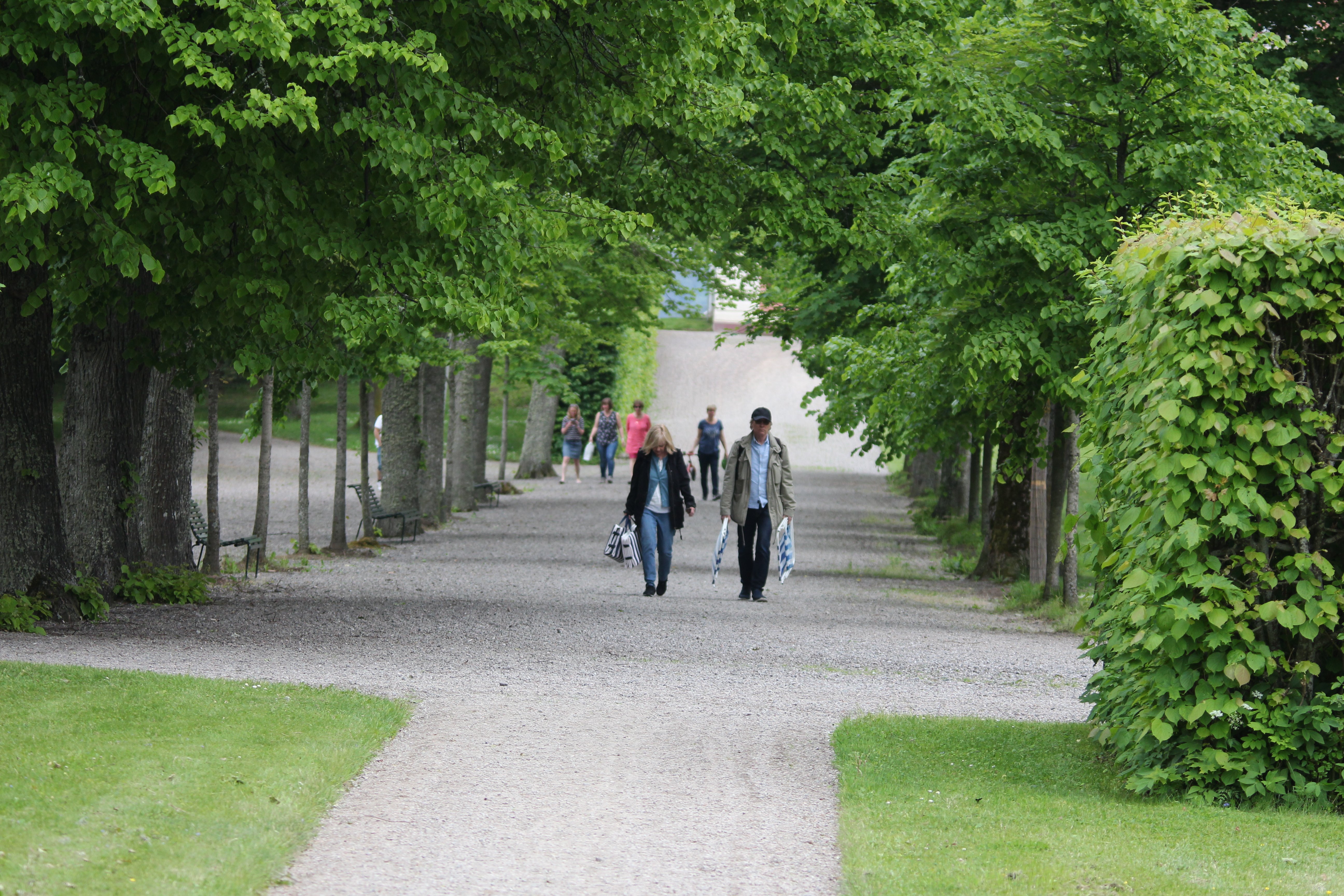 Besökare promenerar på grusad stig i slottsmiljön